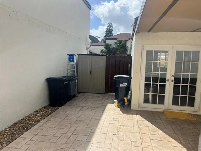 a view of a porch with chairs and potted plants