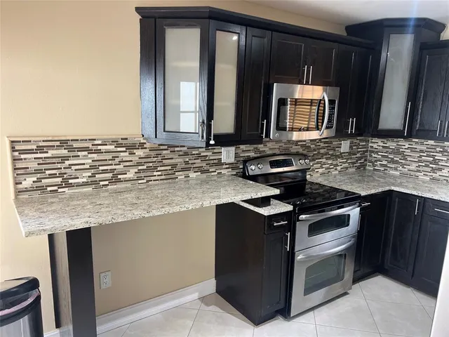 a kitchen with granite countertop a sink and a stove