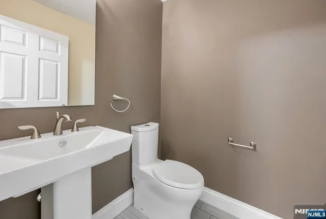 a bathroom with a sink a toilet and mirror