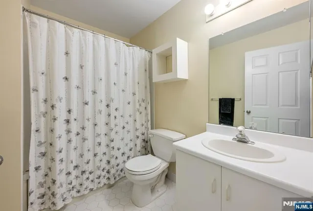 a bathroom with a sink a toilet and shower curtain