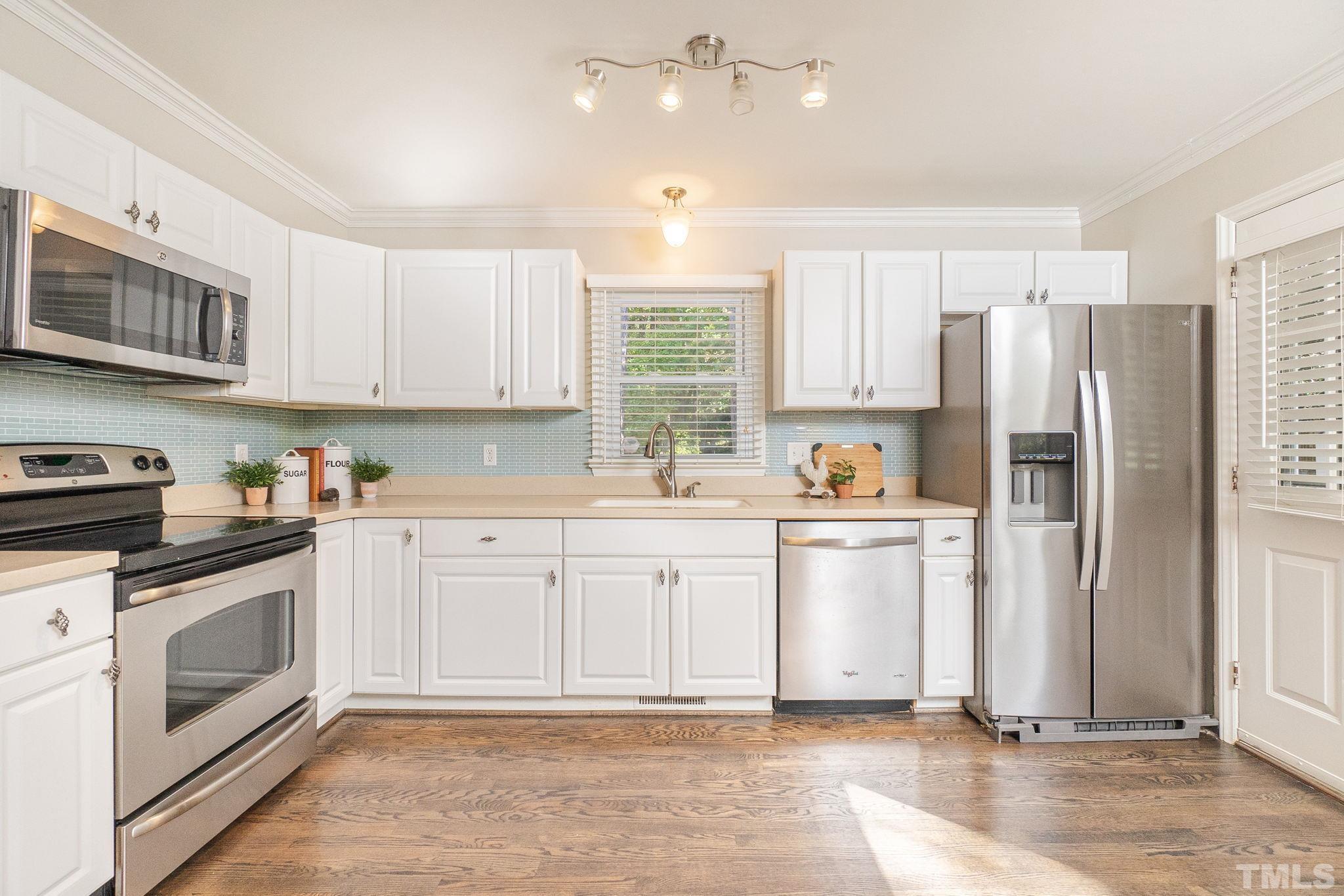 7544 Milestone Court Raleigh, NC 27615 - Photo 13 of 30 a kitchen with granite countertop a refrigerator stove and sink