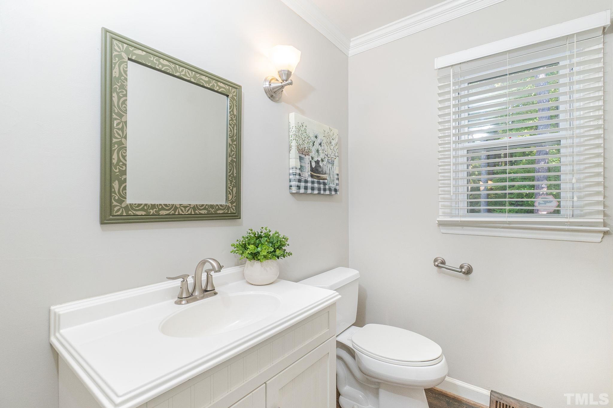 7544 Milestone Court Raleigh, NC 27615 - Photo 14 of 30 a bathroom with a sink vanity mirror and toilet