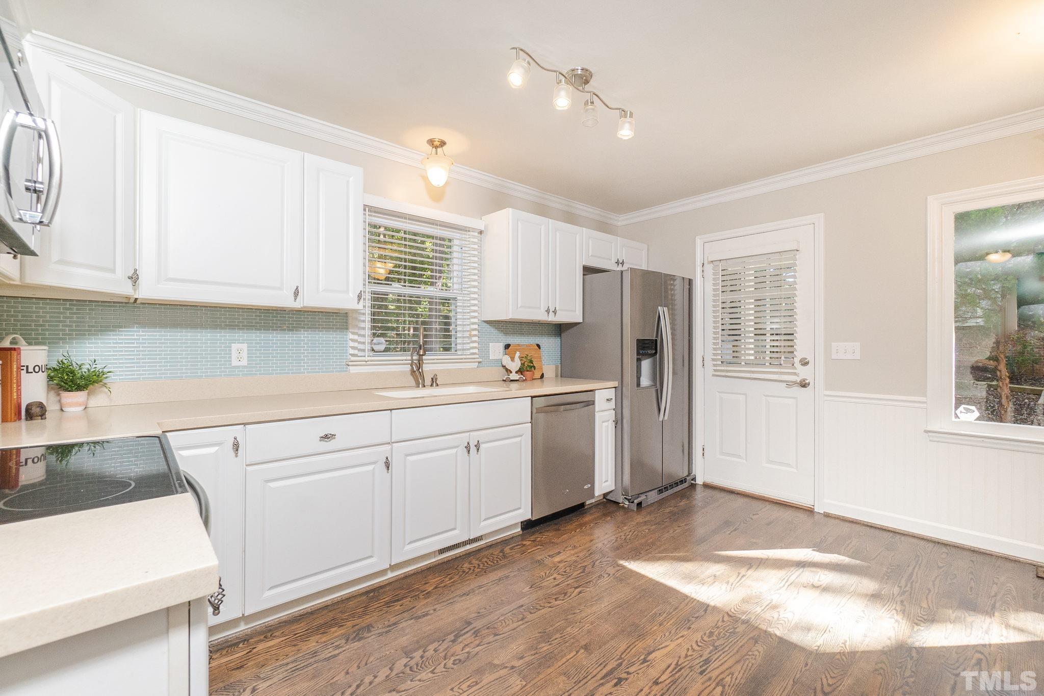 7544 Milestone Court Raleigh, NC 27615 - Photo 10 of 30 a kitchen with white cabinets and white appliances