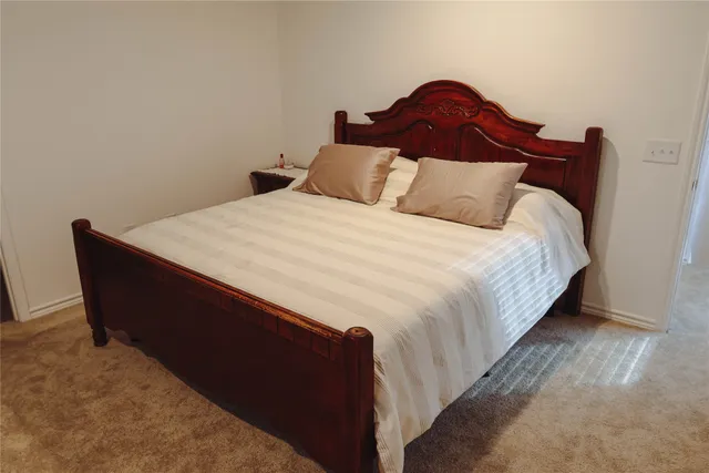 a large bed sitting in a bedroom next to a wooden cabinet