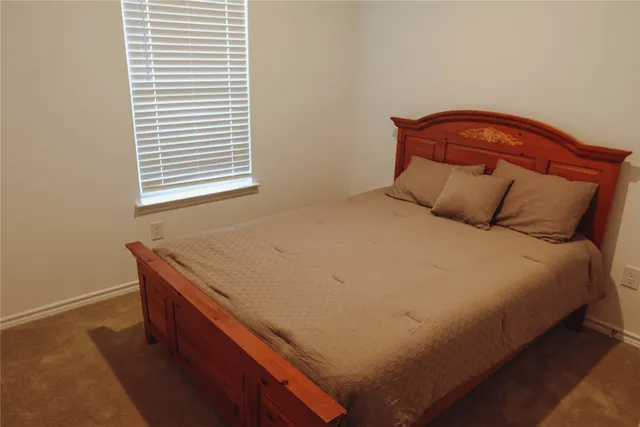 a bed sitting in a bedroom next to a window