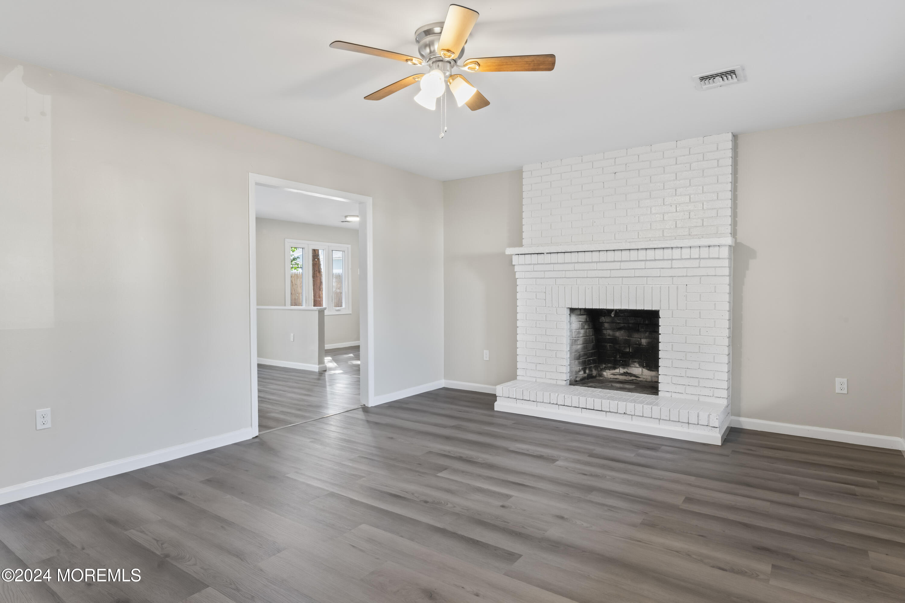 321 Float Avenue Manahawkin, NJ 08050 - Photo 16 of 31 a view of an empty room with wooden floor a fireplace and a window