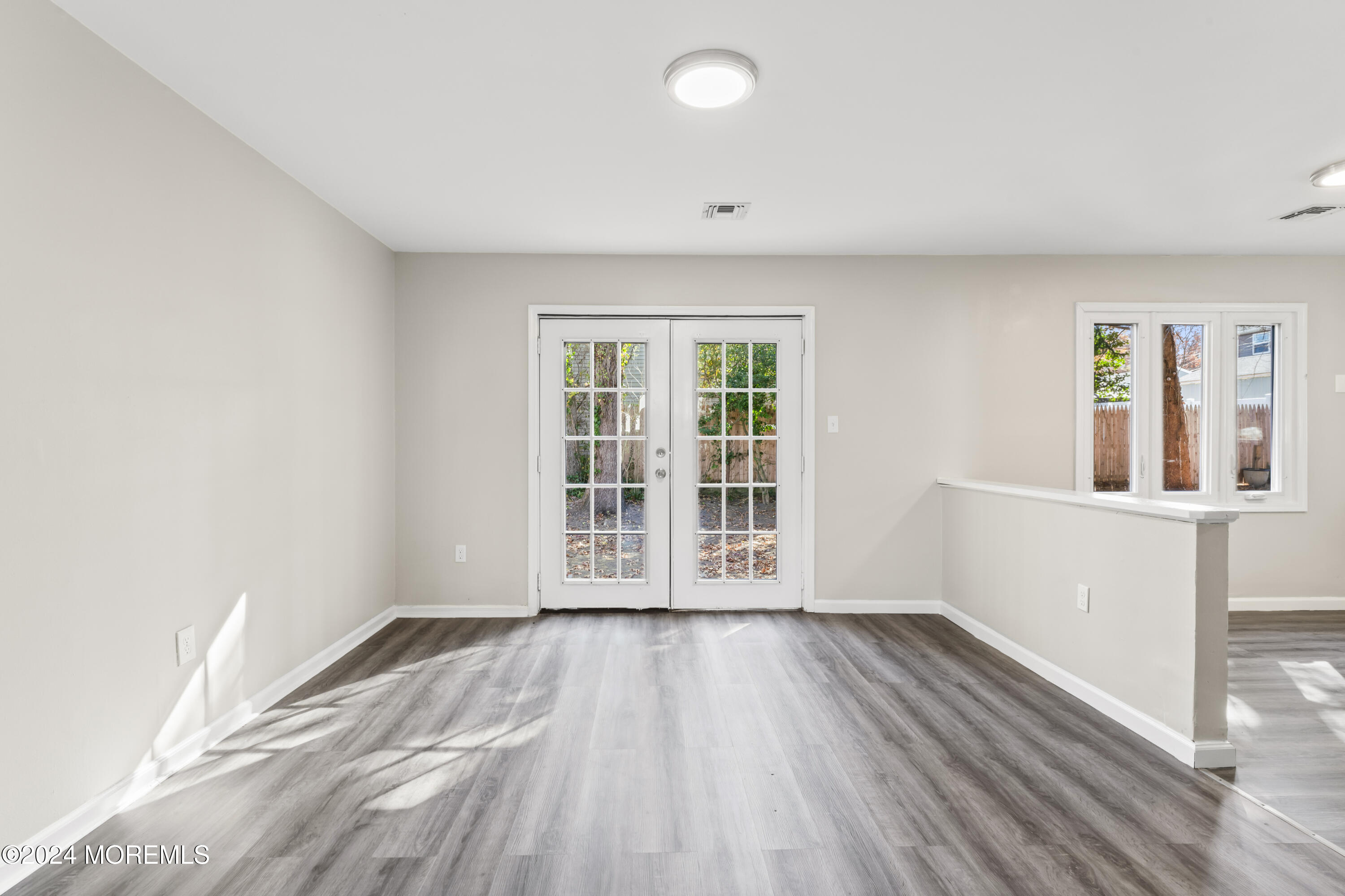 321 Float Avenue Manahawkin, NJ 08050 - Photo 3 of 31 an empty room with wooden floor and windows