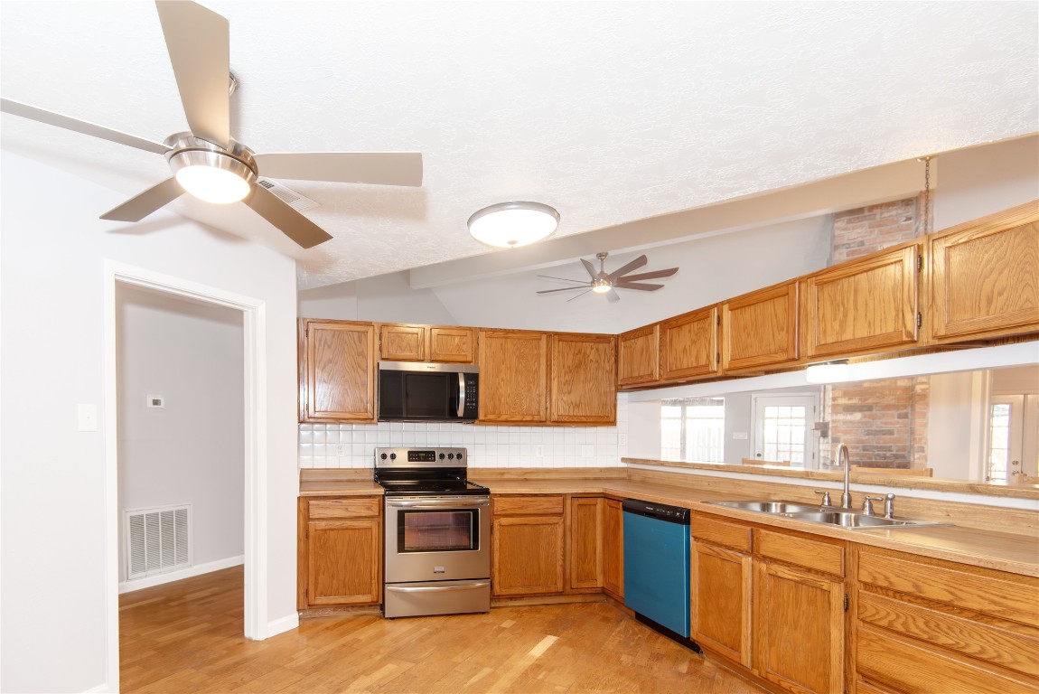 21734 Nickerton Lane Spring, TX 77388 - Photo 4 of 31 View of the kitchen featuring a convenient pass-through to the living room and updated stainless-steel appliances.