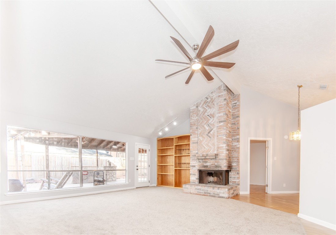 21734 Nickerton Lane Spring, TX 77388 - Photo 8 of 31 Bright living room with tall ceilings, built-in shelving, and a cozy brick fireplace.