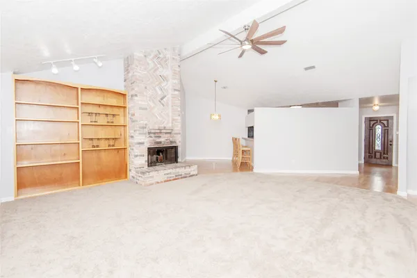a big room with chandelier fan and windows