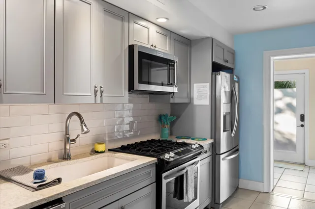 a kitchen with stainless steel appliances granite countertop a refrigerator stove and sink