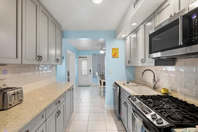 a kitchen with stainless steel appliances granite countertop a sink stove and refrigerator