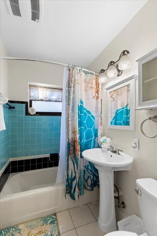 a bedroom with a bed a flat screen tv and a chandelier