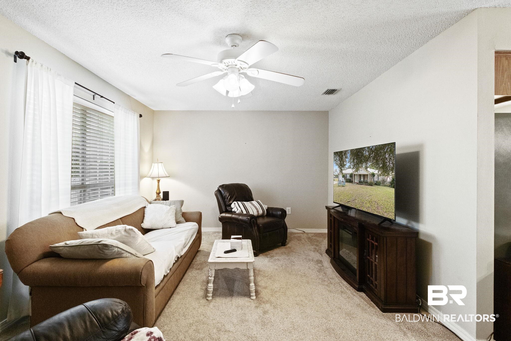 14031 Brook Hollow Road Summerdale, AL 36580 - Photo 11 of 56 Living room with a textured ceiling, light colored carpet, and ceiling fan