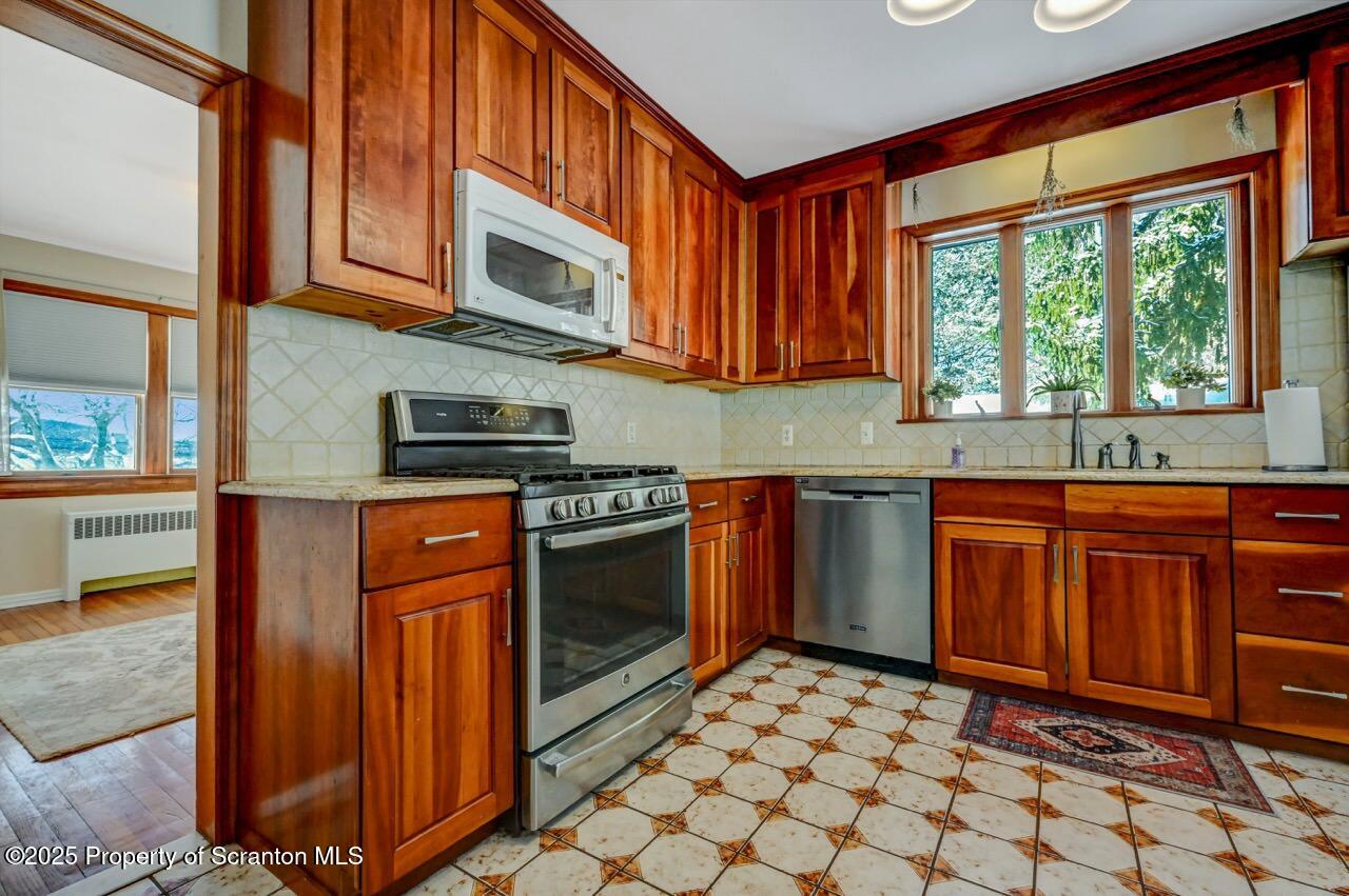 117 Griffin Pond Road Clarks Summit, PA 18411 - Photo 18 of 65 a kitchen with stainless steel appliances granite countertop a stove a sink and a microwave