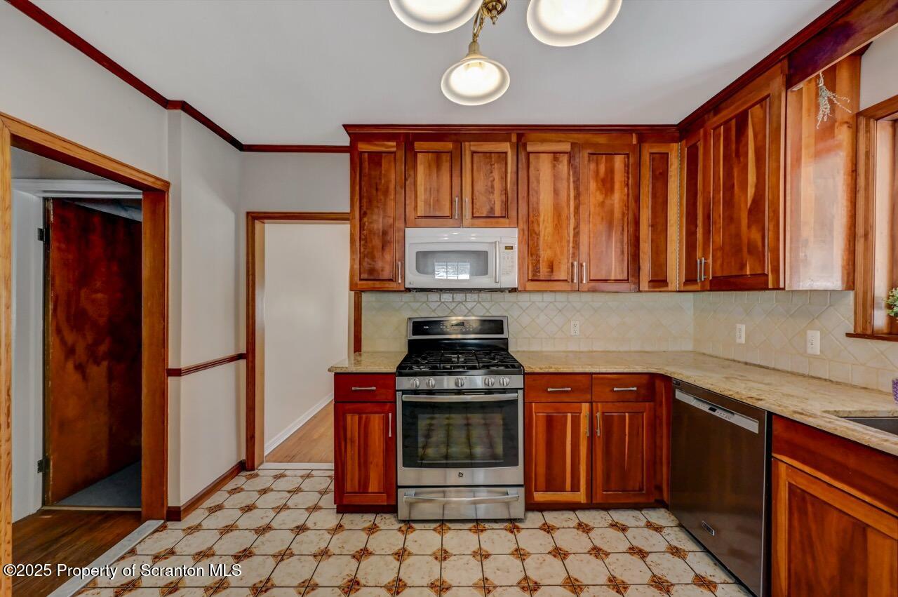 117 Griffin Pond Road Clarks Summit, PA 18411 - Photo 20 of 65 a kitchen with stainless steel appliances granite countertop a stove a sink and a microwave