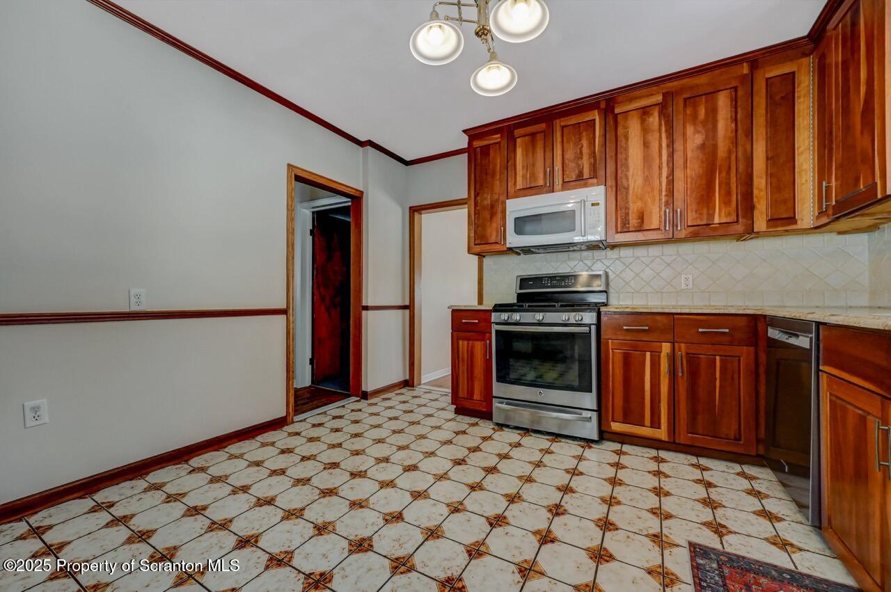 117 Griffin Pond Road Clarks Summit, PA 18411 - Photo 21 of 65 a kitchen with granite countertop a stove cabinets and a sink
