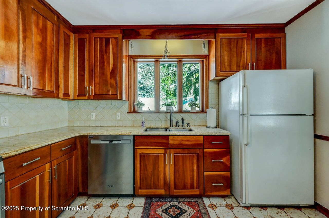 117 Griffin Pond Road Clarks Summit, PA 18411 - Photo 23 of 65 a kitchen with stainless steel appliances granite countertop a refrigerator and a sink