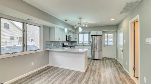 a kitchen with stainless steel appliances a refrigerator a sink a stove and cabinets