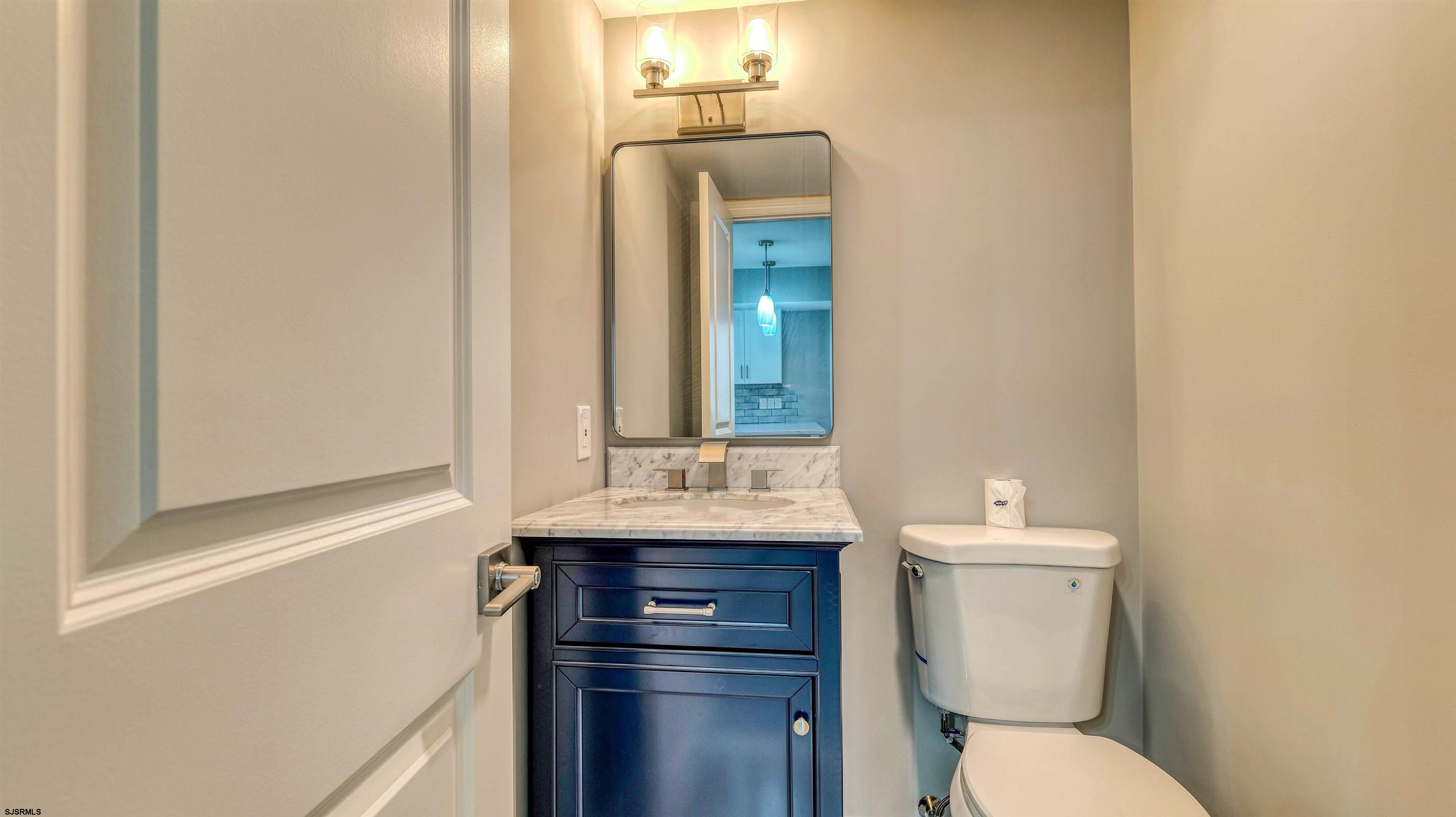 101 11th Street North, Unit A Brigantine, NJ 08203 - Photo 3 of 42 a bathroom with a toilet a sink and mirror