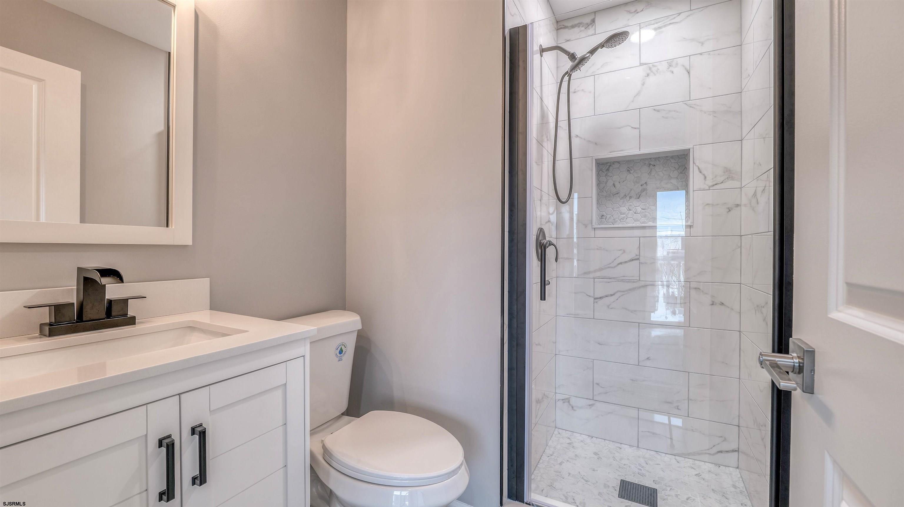 101 11th Street North, Unit A Brigantine, NJ 08203 - Photo 36 of 42 a bathroom with a sink a toilet and shower
