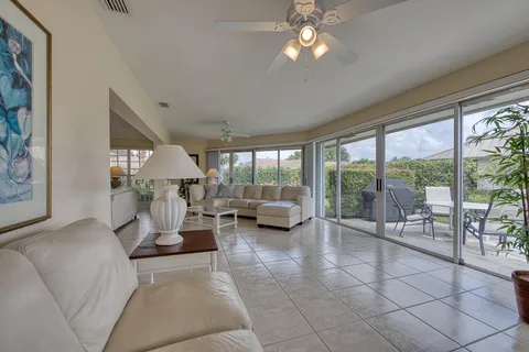 a living room with furniture and a large window with balcony view