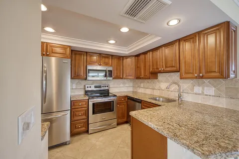 a kitchen with stainless steel appliances granite countertop refrigerator sink and cabinets