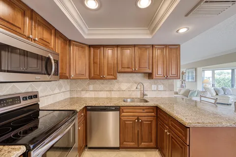 a kitchen with a sink appliances cabinets and a window