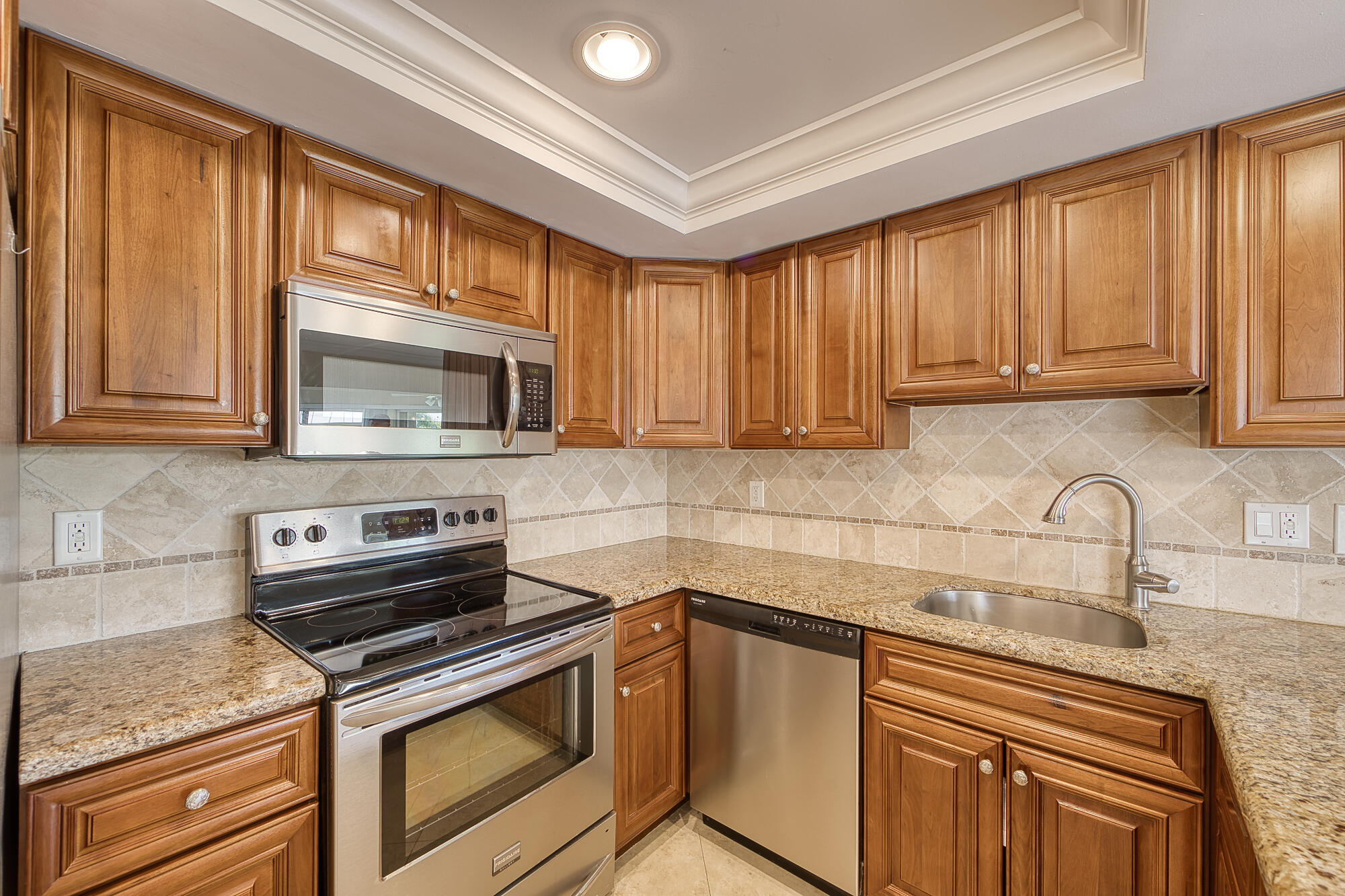 328 Cedar Key Circle Atlantis, FL 33462 - Photo 14 of 28 a kitchen with granite countertop a stove top oven microwave and cabinets