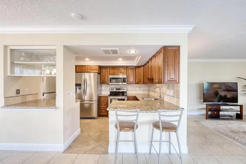a kitchen with stainless steel appliances kitchen island granite countertop a refrigerator and a stove