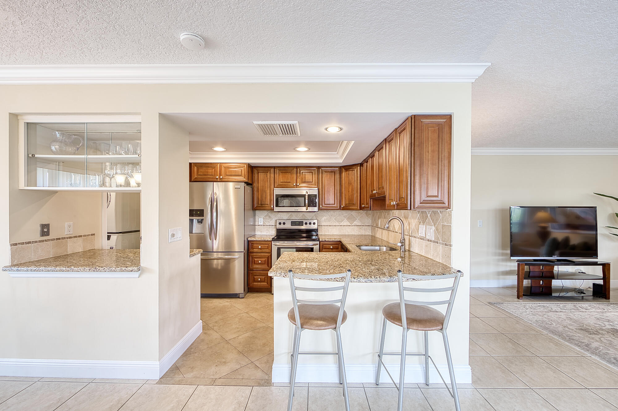 328 Cedar Key Circle Atlantis, FL 33462 - Photo 16 of 28 a kitchen with stainless steel appliances kitchen island granite countertop a refrigerator and a stove