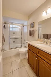 a spacious bathroom with a shower a sink and a mirror