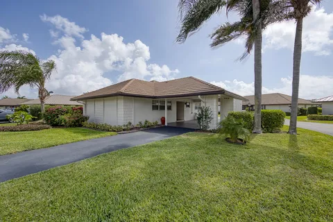 a view of a house with a big yard plants and large trees