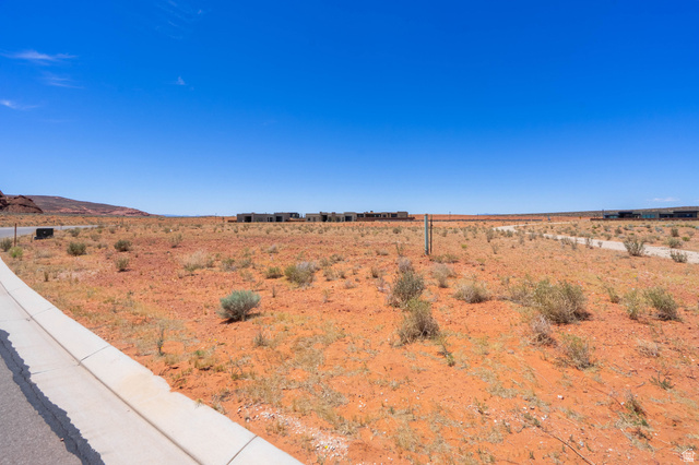 3306 South Endless Trail, Unit 33 Hurricane, UT 84737 - Photo 3 of 27 Expansive undeveloped lot featuring a paved road, concrete curb, and desert landscape