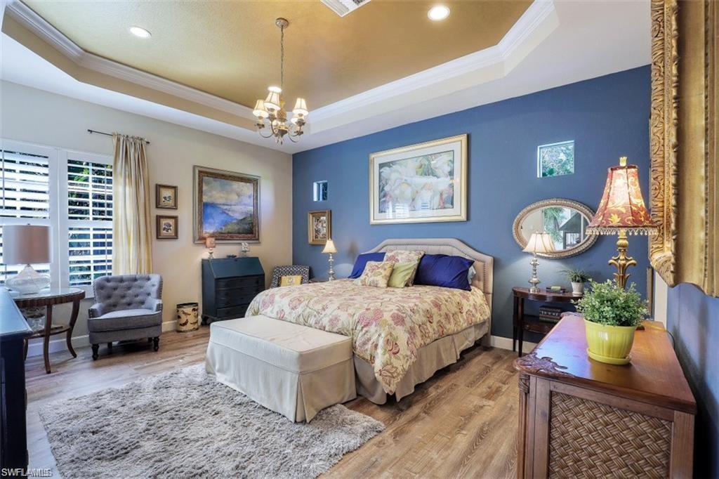 16156 Parque Lane Naples, FL 34110 - Photo 13 of 21 a bedroom with bed and a chandelier