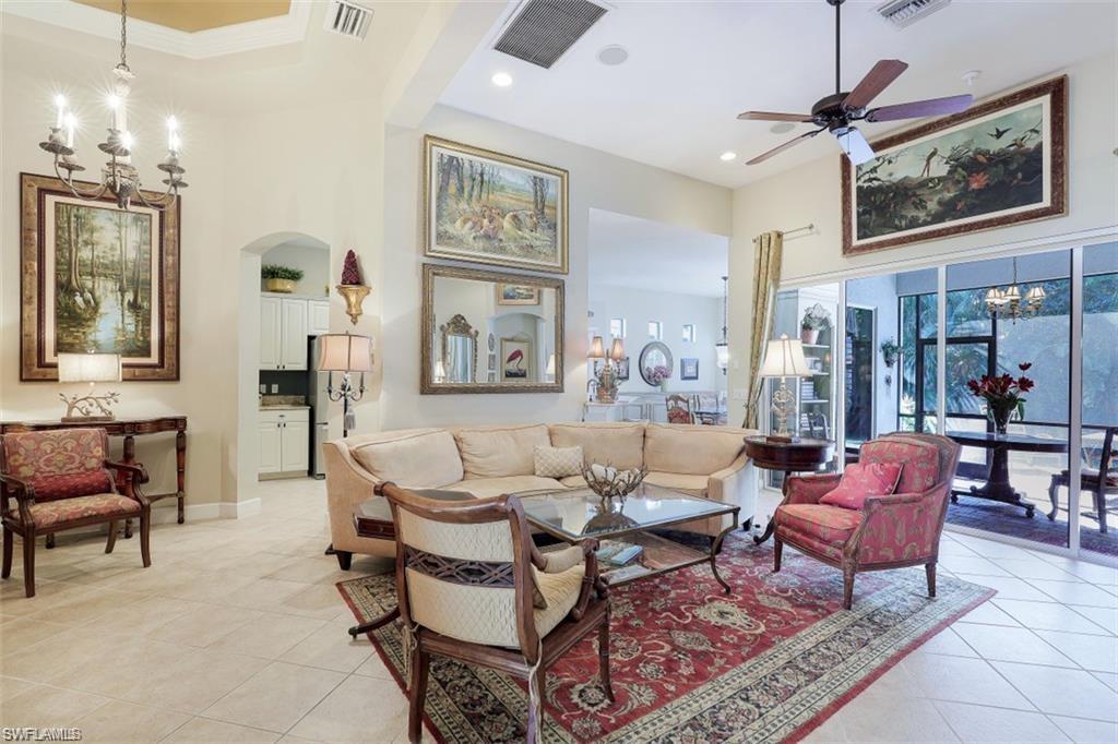 16156 Parque Lane Naples, FL 34110 - Photo 8 of 21 a living room with furniture a chandelier and a painting on the wall