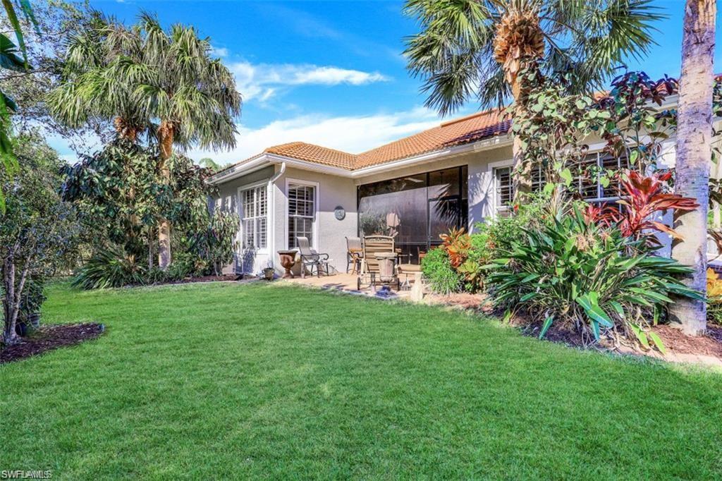 16156 Parque Lane Naples, FL 34110 - Photo 10 of 21 a backyard of a house with table and chairs plants and large tree