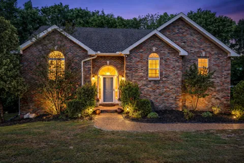 a front view of house with a garden