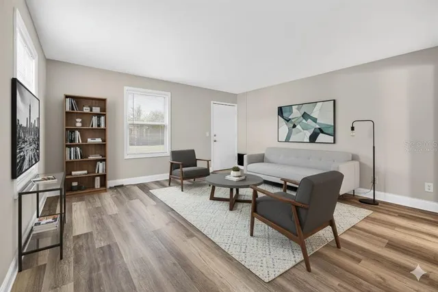 a living room with furniture and a hard wood floor