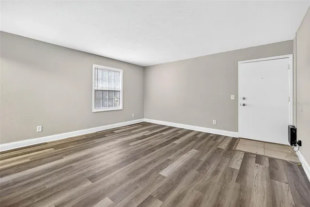 wooden floor in an empty room with a window