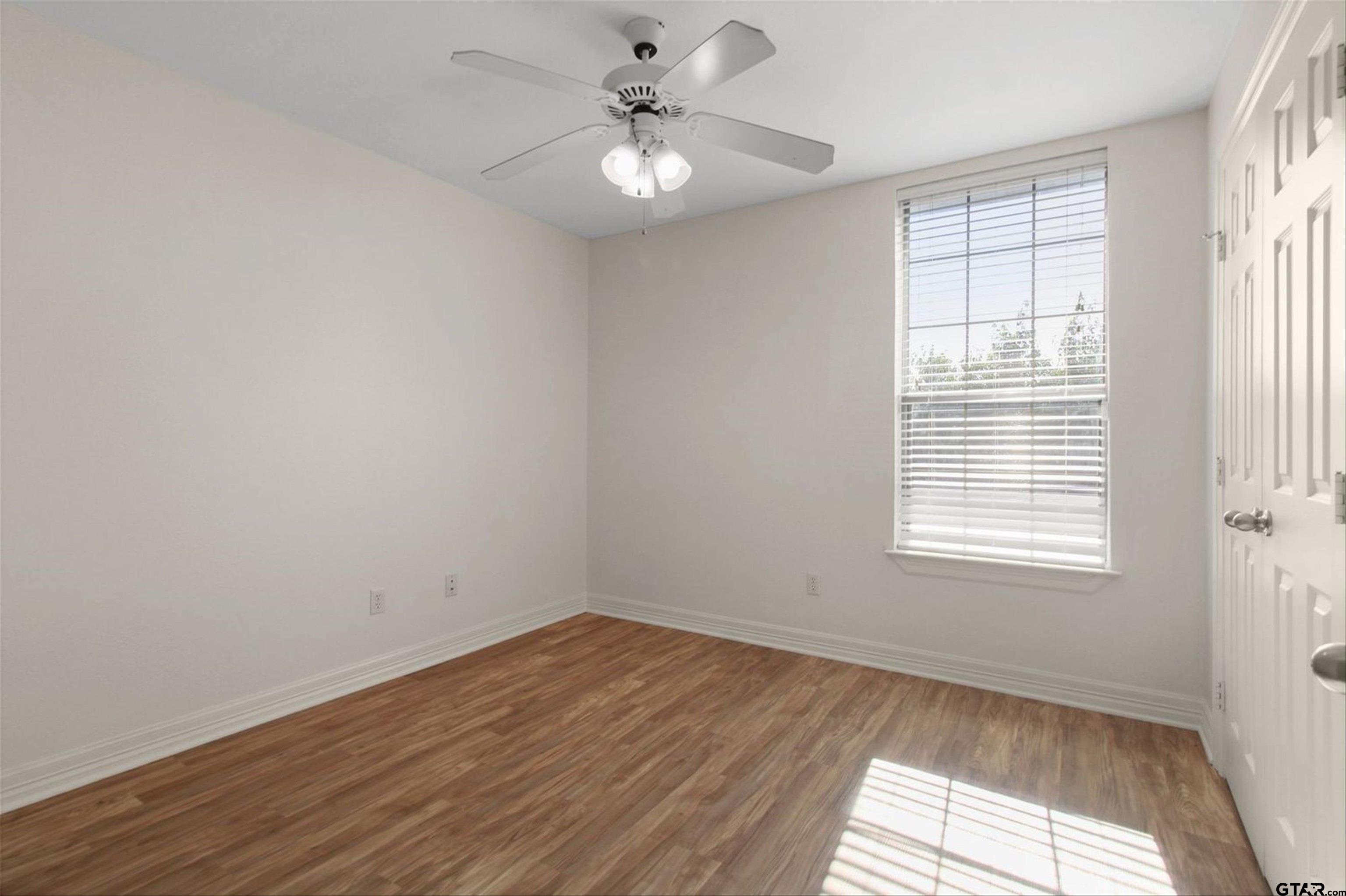452 Princess Place Tyler, TX 75704 - Photo 17 of 20 a view of an empty room with a window and wooden floor