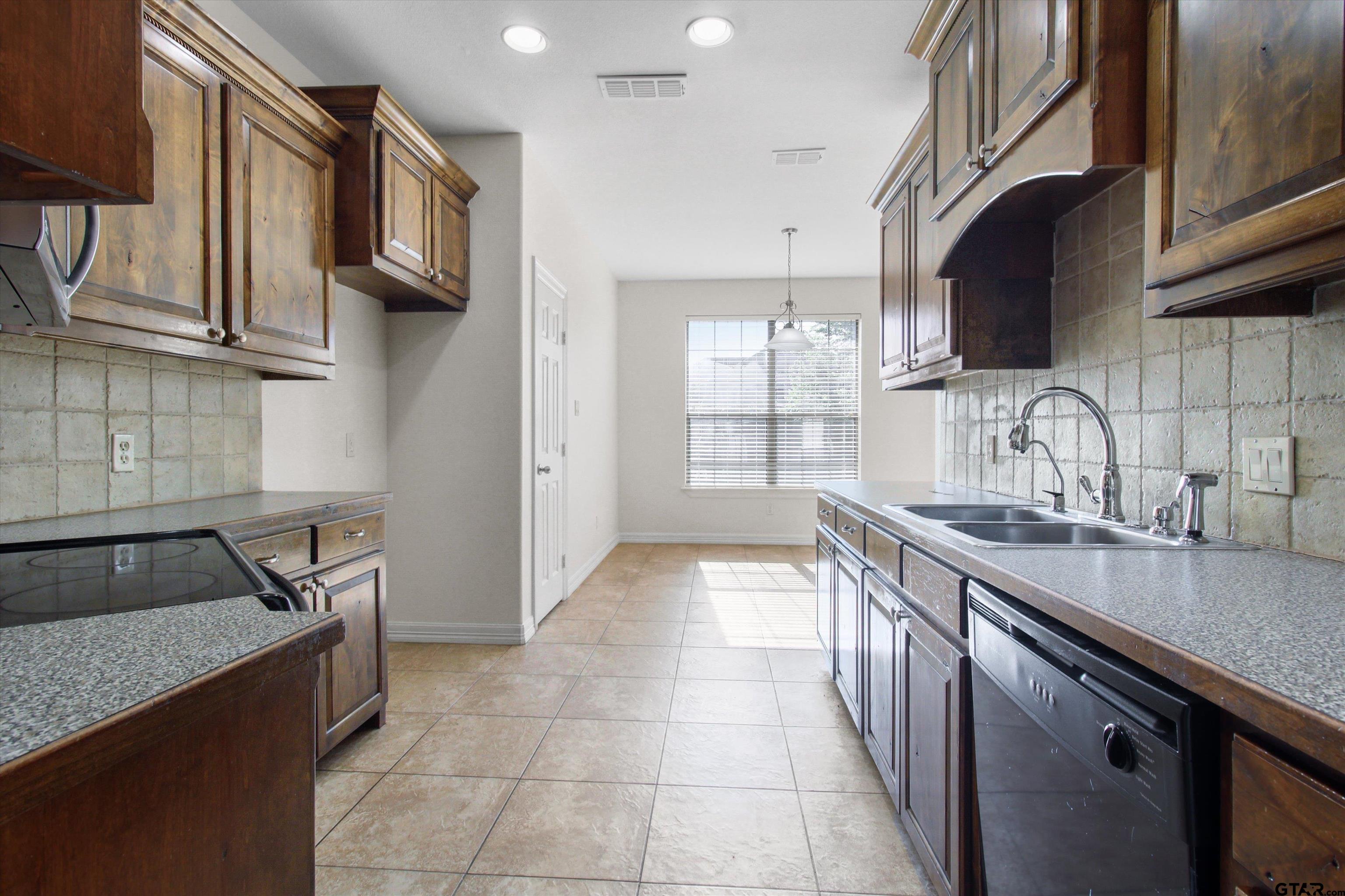 452 Princess Place Tyler, TX 75704 - Photo 5 of 20 a kitchen with stainless steel appliances a sink stove and cabinets