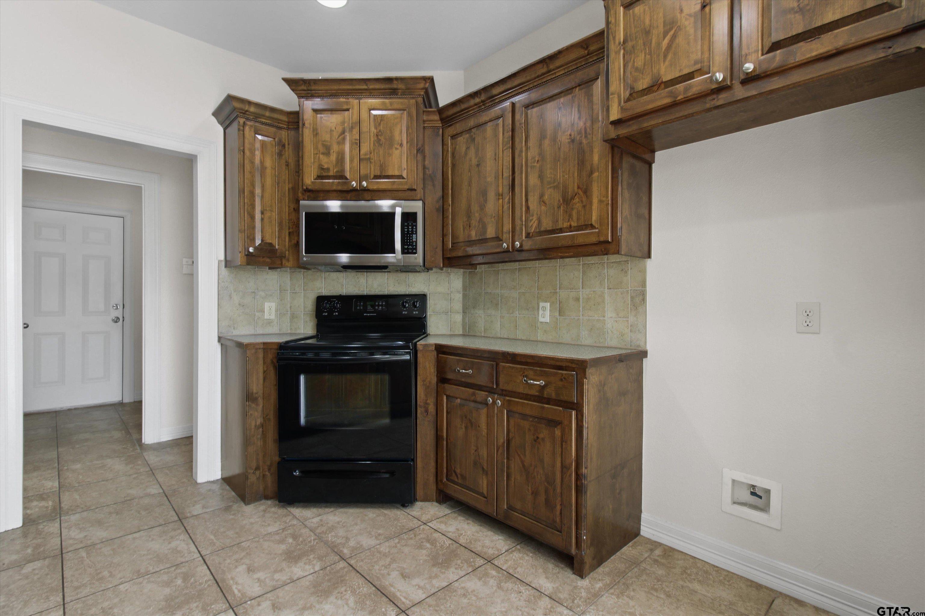 452 Princess Place Tyler, TX 75704 - Photo 7 of 20 a kitchen with stainless steel appliances granite countertop a stove and a microwave oven