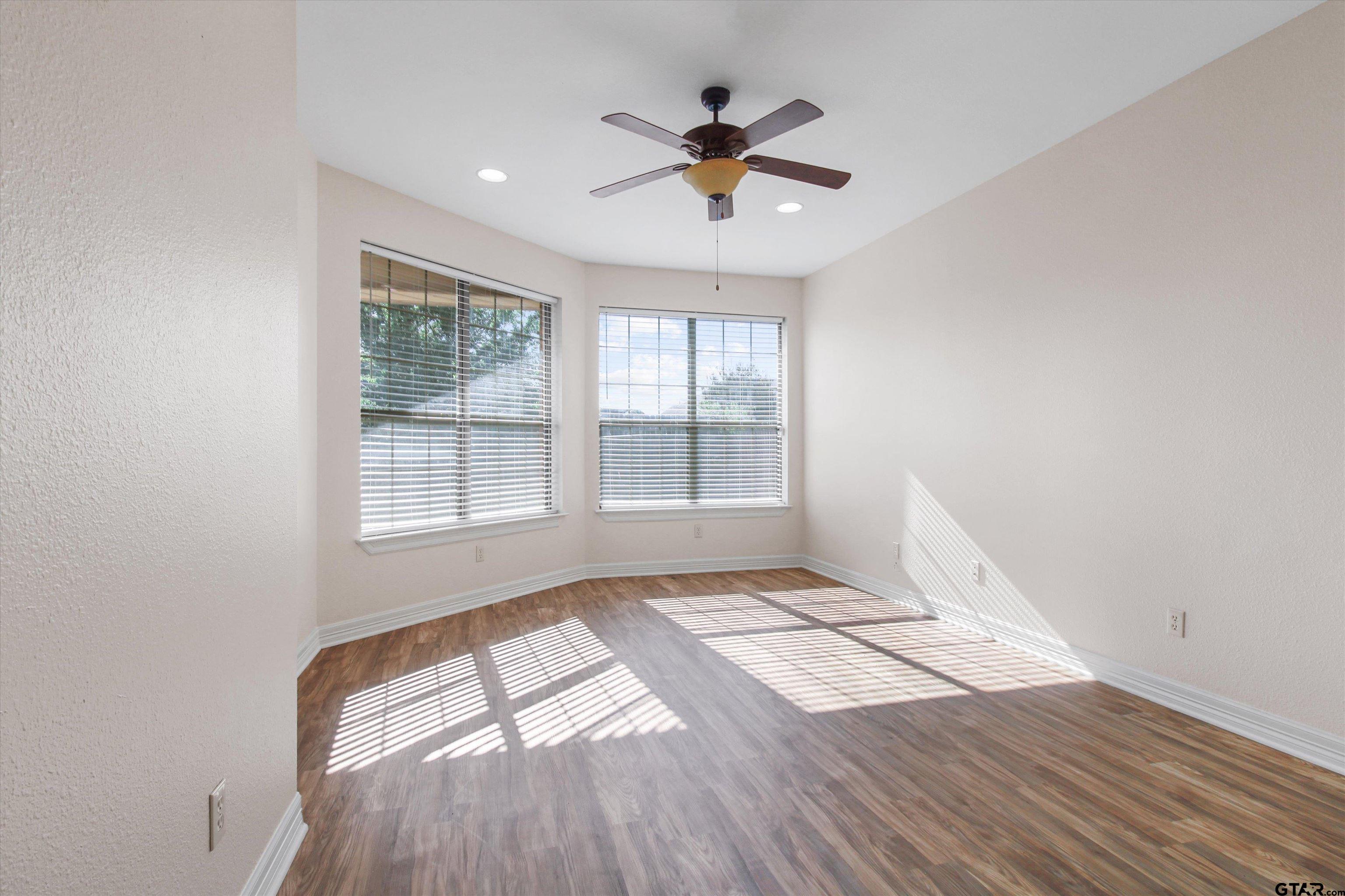 452 Princess Place Tyler, TX 75704 - Photo 8 of 20 a view of an empty room with wooden floor and a window