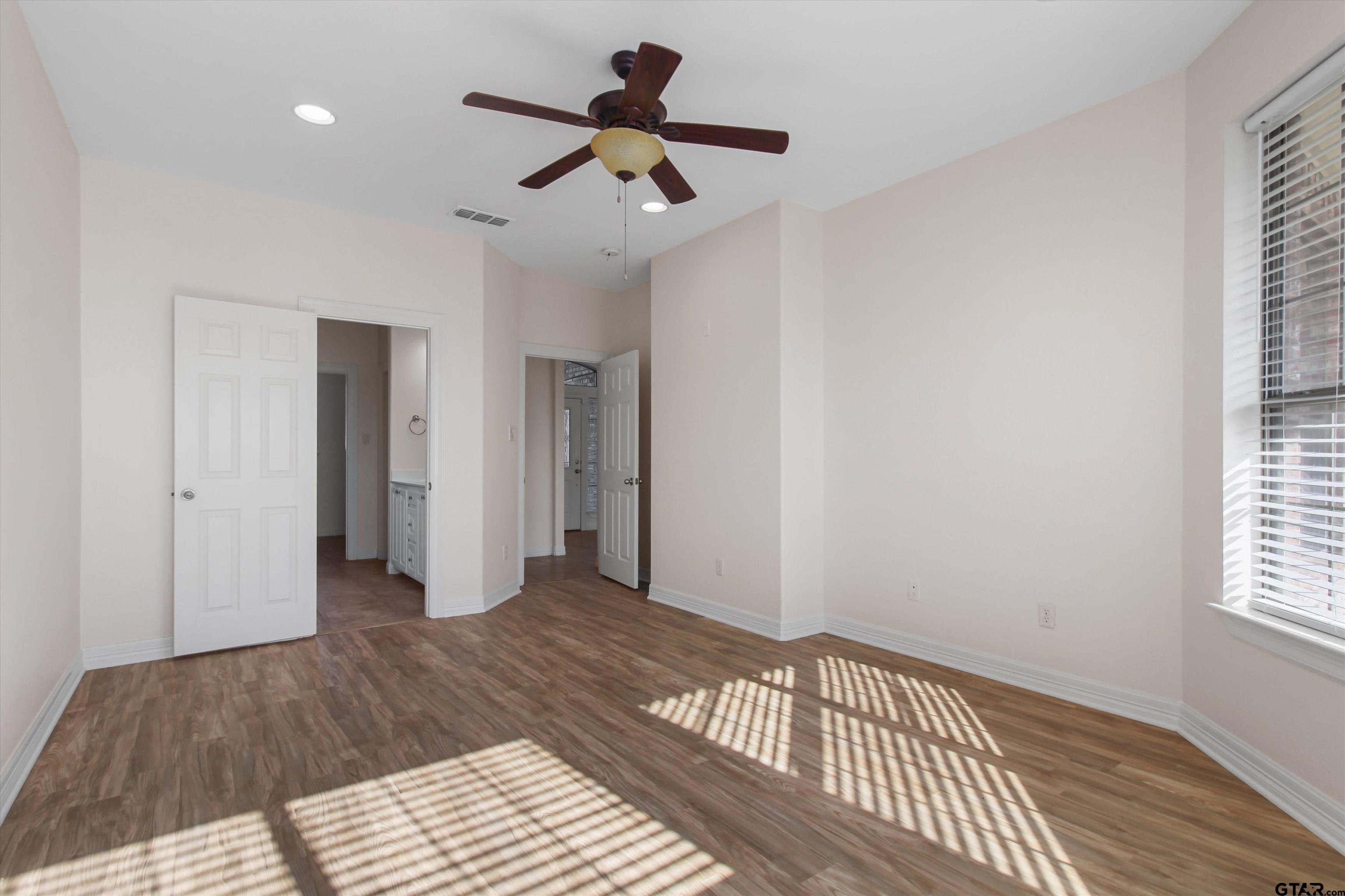452 Princess Place Tyler, TX 75704 - Photo 9 of 20 a view of a room with a ceiling fan wooden floor and a window