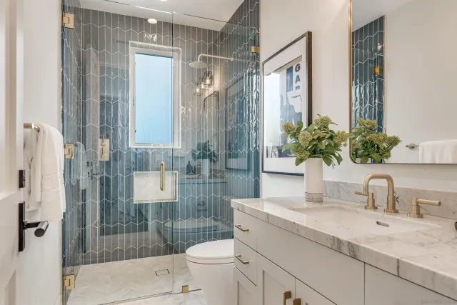 a bathroom with a granite countertop sink toilet and shower