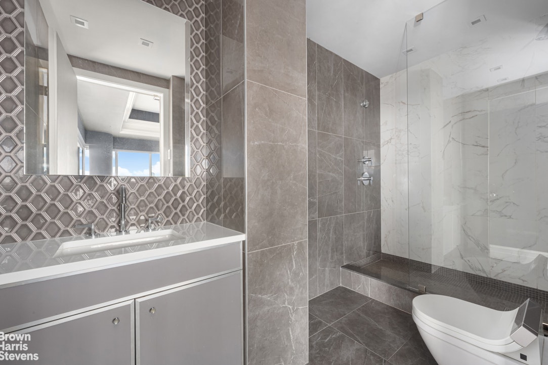 200 East 69th Street, Unit 47 Manhattan, NY 10021 - Photo 14 of 29 a bathroom with a sink a toilet and shower