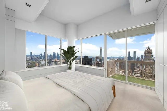 a spacious bedroom with a large window and a bed