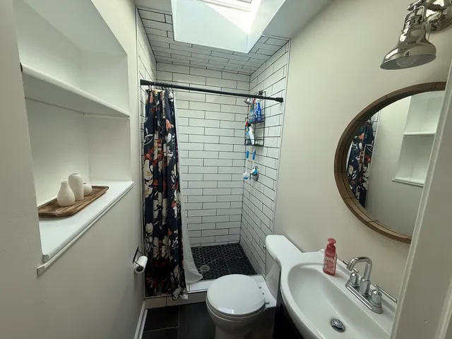 a bathroom with a granite countertop toilet sink and mirror
