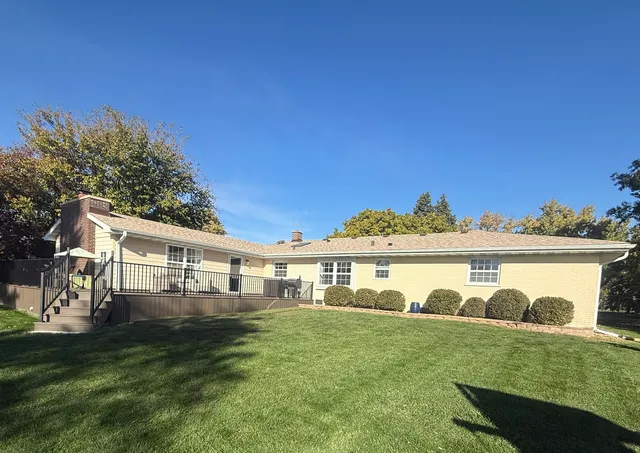 a view of a house with a yard and sitting area